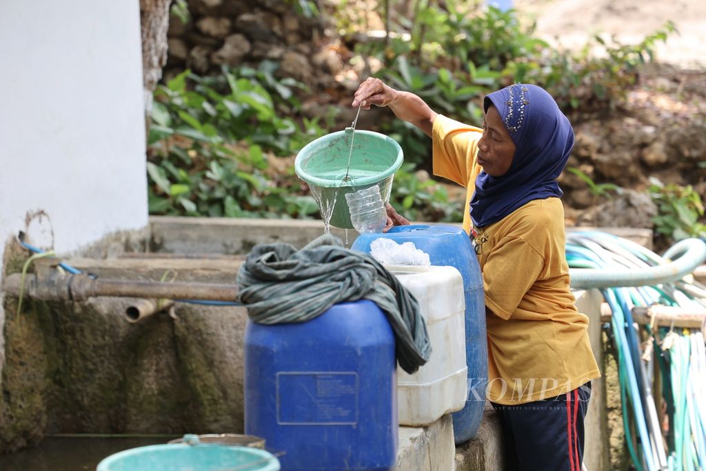 Warga mengambil air dari mata air di Desa Selopamioro, Kabupaten Bantul, Daerah Istimewa Yogyakarta, Selasa (31/10/2023).