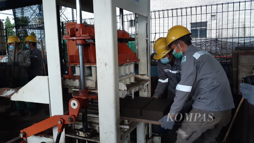 Pekerja mencetak balok paving dengan bahan baku limbah hasil pembakaran batubara di Workshop Pemanfaatan Fly Ash dan Bottom Ash Unit Pembangkitan Jawa Bali Paiton Baru, Jawa Timur, Jumat (4/2/2022).