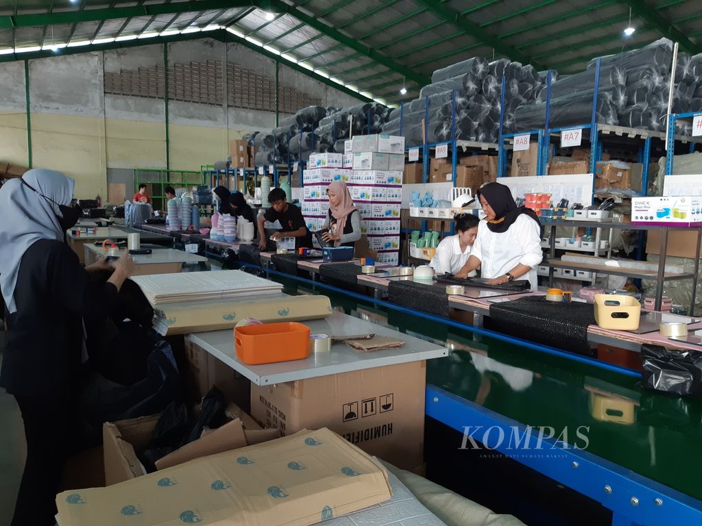 Para karyawan salah satu <i>seller </i>penjualan produk sibuk mengemas sejumlah produk yang dibeli konsumen secara daring, Selasa (10/10/2023), di Jalan Industri, Kecamatan Cikupa, Kabupaten Tangerang, Banten. Penjualan <i>seller </i>tersebut turun drastis sejak Tiktok Shop dilarang pemerintah.