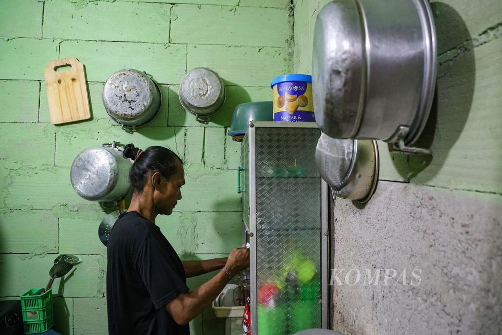 Jhon Pebri (43) takes a glass from the shelf at the Ragam Berdaya Indonesia Shelter, West Jakarta, Friday (12/4/2024).