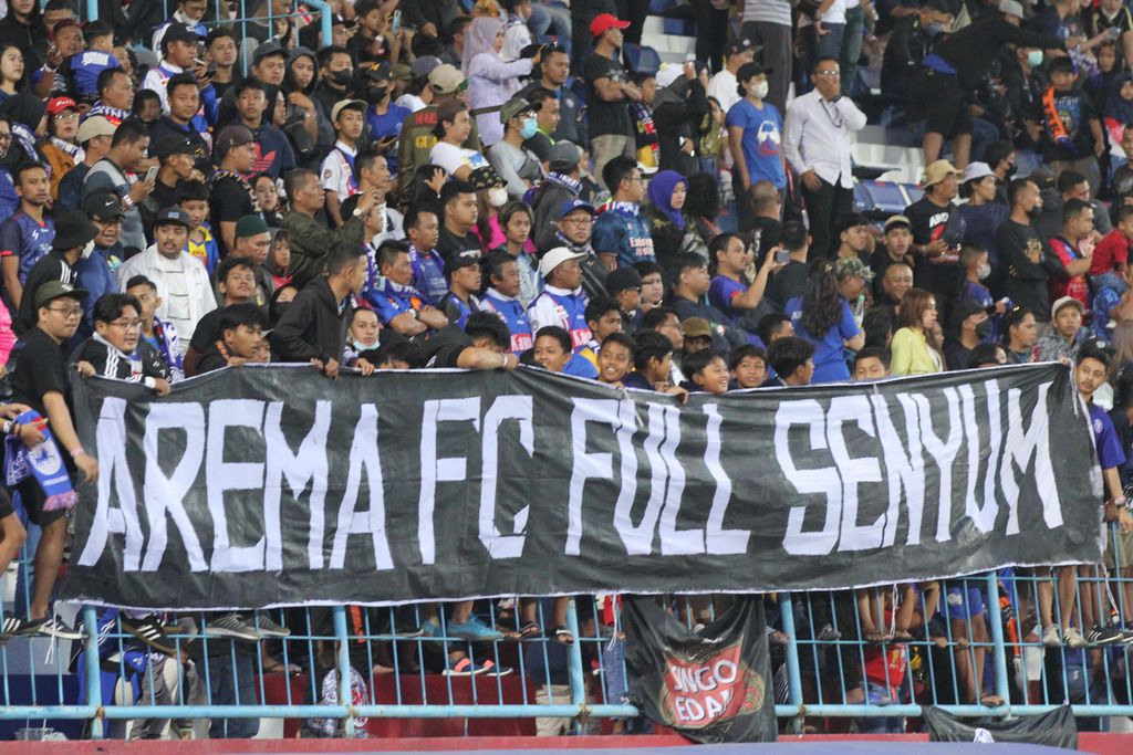 Suporter Arema FC, Aremania, membentangkan spanduk dukungan kepada klub kesayangan mereka saat menghadapi PSIS Semarang dalam laga pertemuan kedua semifinal Piala Presiden 2022 di Stadion Kanjuruhan, Malang, Jawa Timur, Senin (11/7/2022). Arema FC lantas ke final dan menjadi juara turnamen pramusim itu.