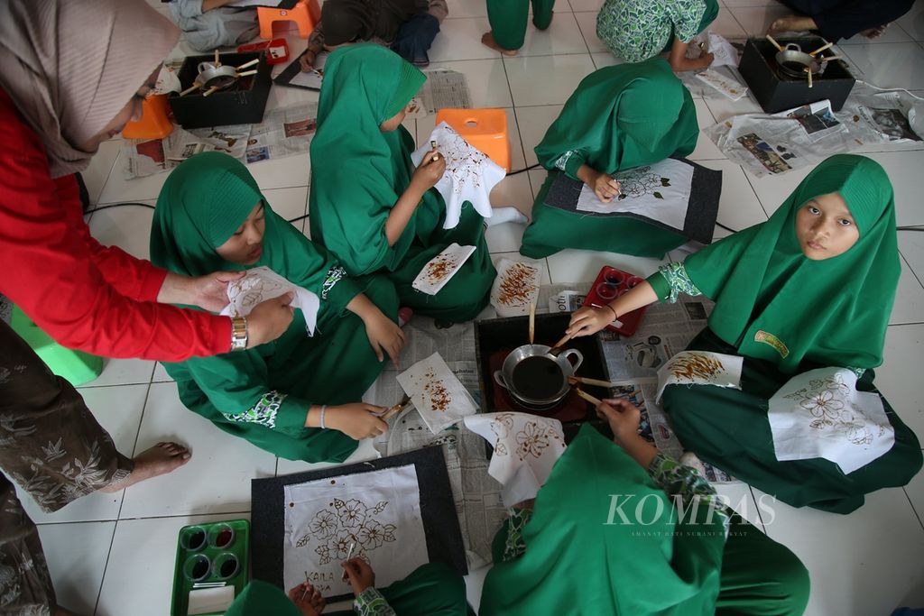 Siswa kelas VI SD Al Lauzah, Tangerang Selatan, Banten, belajar membatik di sekolahnya, Senin (7/10/2019). Kegiatan ini bertujuan untuk mengenalkan proses membatik yang menjadi warisan budaya asli Indonesia kepada anak-anak. Selain itu, diharapkan menumbuhkan jiwa <i>entrepreneur</i> kepada siswa melalui kegiatan membatik. Sebanyak 143 siswa dibimbing oleh para pembatik dari Sanggar Batik Kembang Mayang. 