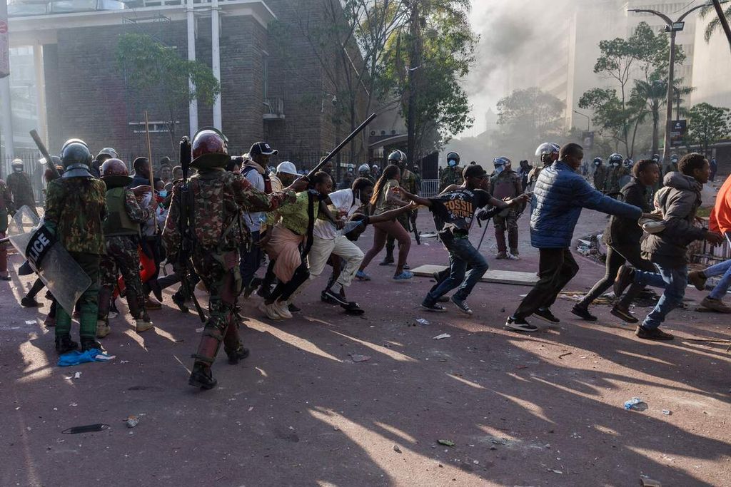 Para pengunjuk rasa berlari menghindari penangkapan aparat kepolisian dalam demonstrasi dan mogok nasional di Nairobi, Kenya, Selasa (25/6/2024), untuk memprotes rencana kenaikan pajak.