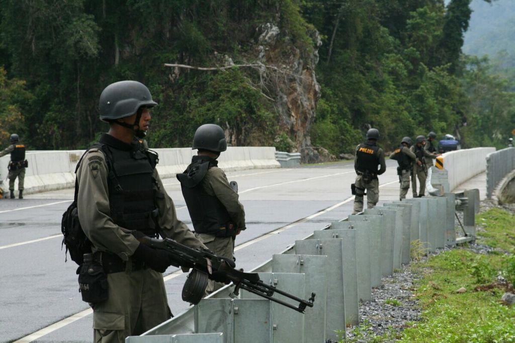 Personel Detasemen Khusus 88 Antiteror bersiaga di Jalan Raya Banda Aceh-Meulaboh Kilometer 24 di Kecamatan Leupung, Kabupaten Aceh Besar, Aceh, Jumat (12/3). Di lokasi tersebut, dua tersangka teroris, Enceng Kurnia dan Jaja, tewas tertembak, sedangkan delapan tersangka lainnya ditangkap hidup-hidup.