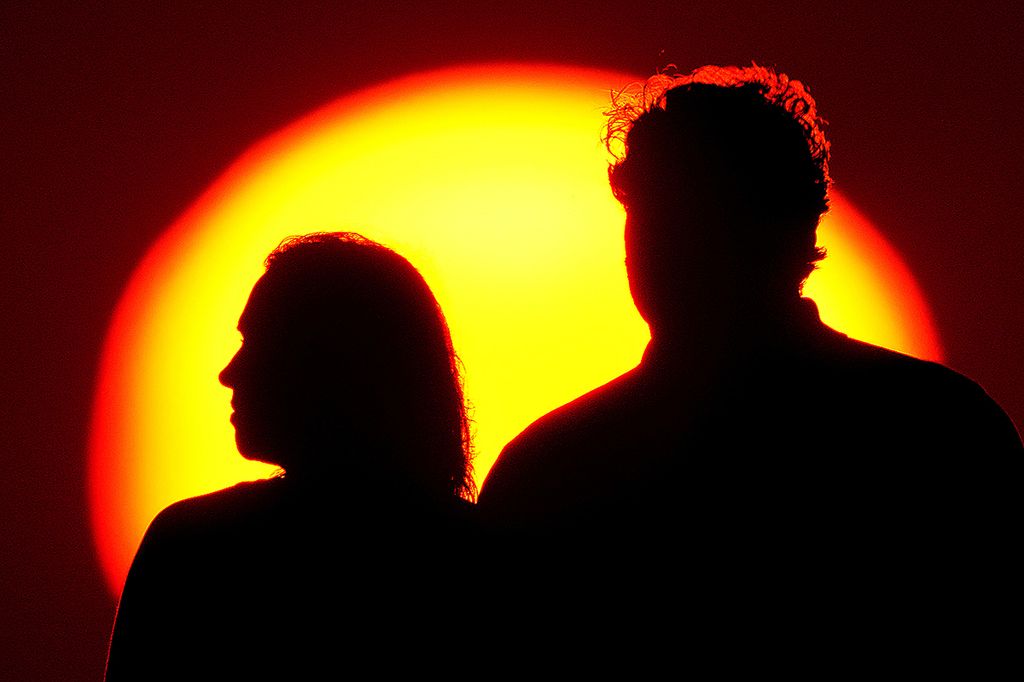 Sepasang pria dan wanita tengah menatap Matahari senja di Kansas, Amerika Serikat, 10 Juli 2021. 