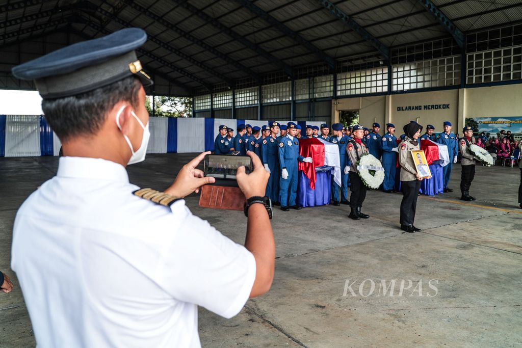 Seorang pilot mengabadikan prosesi pelepasan dua jenazah korban jatuhnya helikopter jenis Bolkow NBO 105 Polri bernomor registrasi P-1103 di perairan Manggar, Belitung Timur, Provinsi Kepulauan Bangka Belitung, yakni kopilot Briptu (anumerta) M Lasminto dan teknisi Bripda (anumerta) M Chairul Anam untuk dikebumikan di daerah masing-masing, dari Markas Kepolisian Perairan dan Udara, Pondok Cabe, Tangerang Selatan, Banten, Rabu (30/11/2022). 