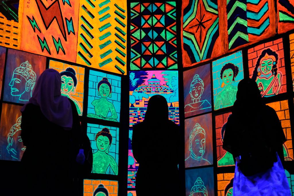 Pengunjung melihat lukisan berbahan <i>fluorescent</i> di Bentara Budaya Jakarta, Palmerah, Kota Jakarta, Rabu (12/10/2022). Pameran Tunggal Berdua Trilogi Kenyamanan ini merupakan karya kolaborasi dua artis, yakni Dwi Putro dan Nawa Tunggal.