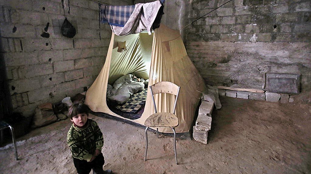  Seorang anak lak-laki Suriah berdiri di dekat sebuah tenda yang berada di dalam ruang bawah tanah . Foto itu diambil pada Minggu (28/1). Banyak keluarga di Ghouta timur terpaksa berlindung di dalam ruang bawah tanah setelah rumah mereka hancur karena serangan tentara Suriah. Setidaknya 400 warga sipil tewas sejak rezim Presiden Bashar al-Assad mengintensifkan serangan atas Ghouta timur yang menjadi kantong terakhir kelompok oposisi. Ghouta berada tidak jauh dari Damaskus, ibu kota Suriah. 