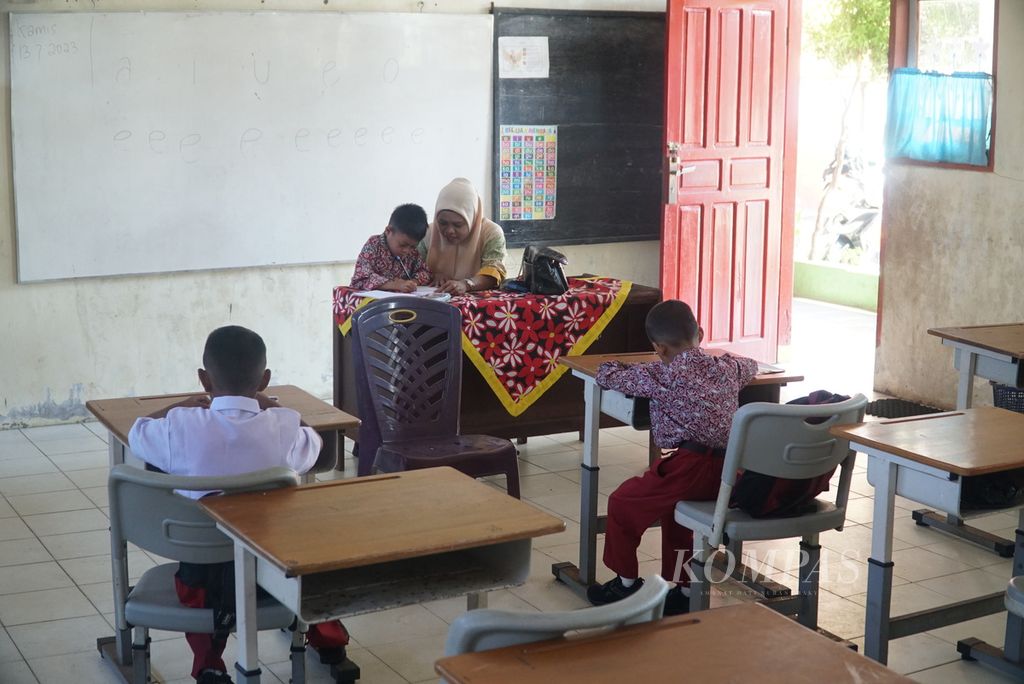 Guru mengajar cara menulis huruf kepada tiga siswa kelas I di SD Negeri 23 Lolong, Kecamatan Padang Utara, Kota Padang, Sumatera Barat, Kamis (13/7/2023). 