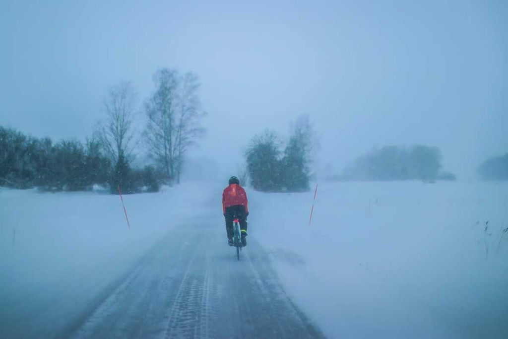 Royke Lumowa saat bersepeda dari Eskilstuna ke Gunnarsokna di Swedia. Badan jalan tertutup salju.