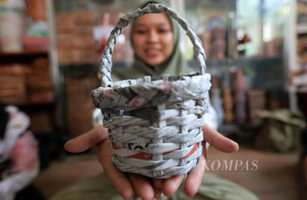 Anggota komunitas lingkungan Go+Muda menunjukkan hasil kreasinya saat belajar membuat kerajinan dari limbah kertas di bank sampah Tri Alam Lestari di Pesanggrahan, Jakarta Selatan, Minggu (6/12/2023). 