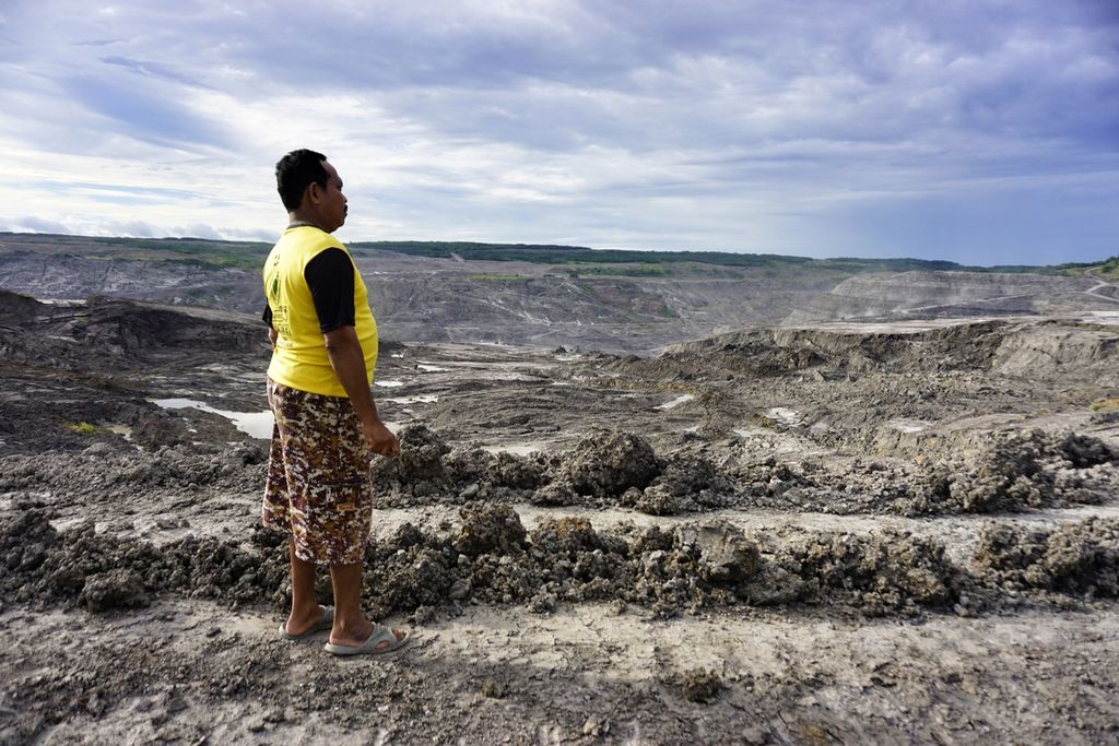 Suratno, salah satu warga Desa Mulawarman, Kecamatan Tenggarong Seberang, Kutai Kartanegara, Kalimantan Timur, melihat lubang tambang yang berada sekitar 300 meter di belakang rumahnya, Minggu (5/1/2019).