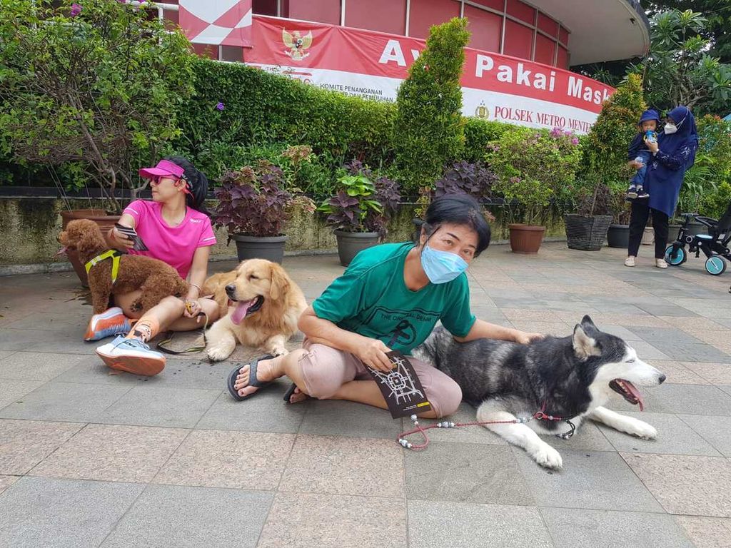 Anggota Komunitas Dog Lovers sedang berpose dengan anjingnya di depan Pos Polisi Bundaran Hotel Indonesia, Jakarta Pusat, saat Hari Bebas Kendaraan Bermotor (16/10/2022).
