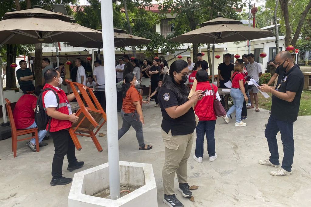 Aparat hukum Filipina, mengenakan rompi warna merah dan kaus hitam, menggerebek kompleks perjudian daring dan penipuan siber di kota Lapu-lapu, Provinsi Cebu, Filipina tengah, Sabtu (31/8/2024). 