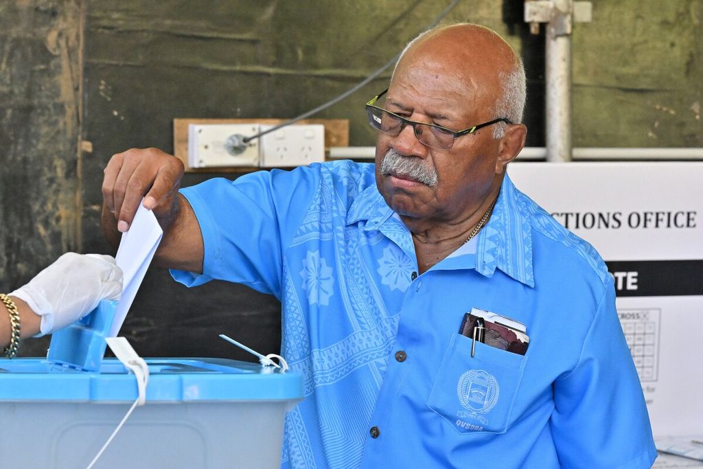 Sitiveni Rabuka, mantan perdana menteri periode 1992-1999 sekaligus pemimpin Partai Aliansi Rakyat, memasukkan surat suara ke dalam kotak suara di sebuah tempat pemungutan sura di ibu kota Suva, Fiji, Rabu (14/12/2022). Dalam pemilu ini, Rabuka kembali mencalonkan diri sebagai PM, menantang PM petahana Frank Bainimarama. 