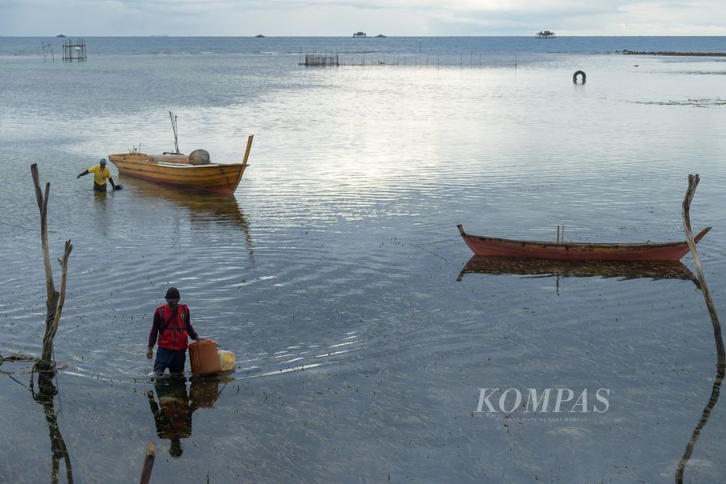 Seorang nelayan melintasi padang lamun di pesisir utara Pulau Bintan, Kepulauan Riau, Rabu (20/10/2021). Ekosistem pesisir ini penting dalam pengendalian perubahan iklim.
