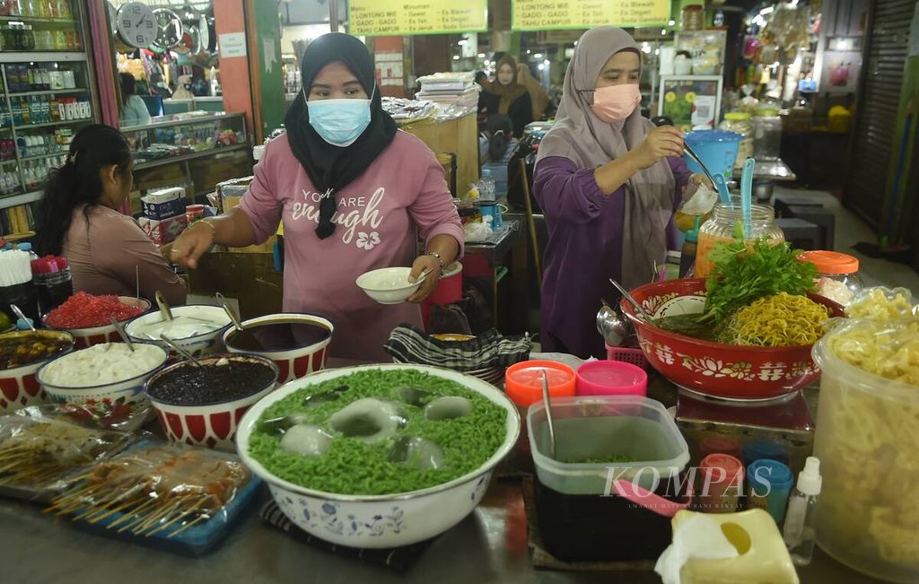 Pedagang menyiapkan es dawet pesanan pembeli di sentra penjualan makanan tradisional di Pasar Blauran, Kota Surabaya, Minggu (13/2/2022). Pasar dibuka dari pukul 06.00 hingga jam 20.00. Menu makanan tradisional yang dijual seperti lontong mie, gado-gado, tahu campur dengan minuman es dawet.