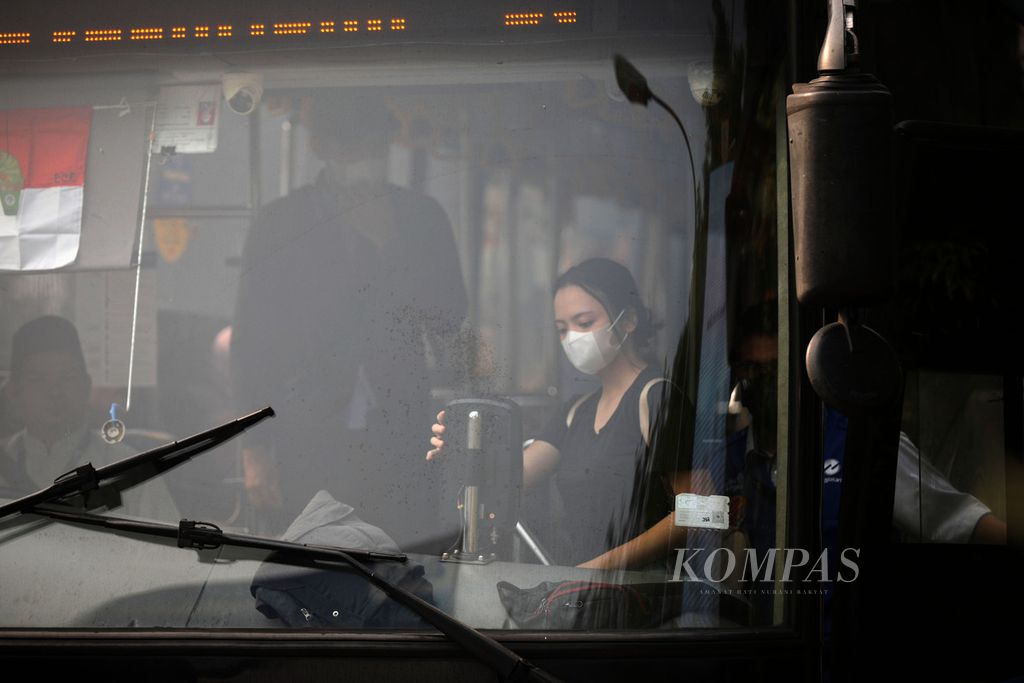 Penumpang bus mengenakan masker saat naik bus di Jalan Serpong Raya, Tangerang Selatan, Banten, Jumat (11/8/2023). 