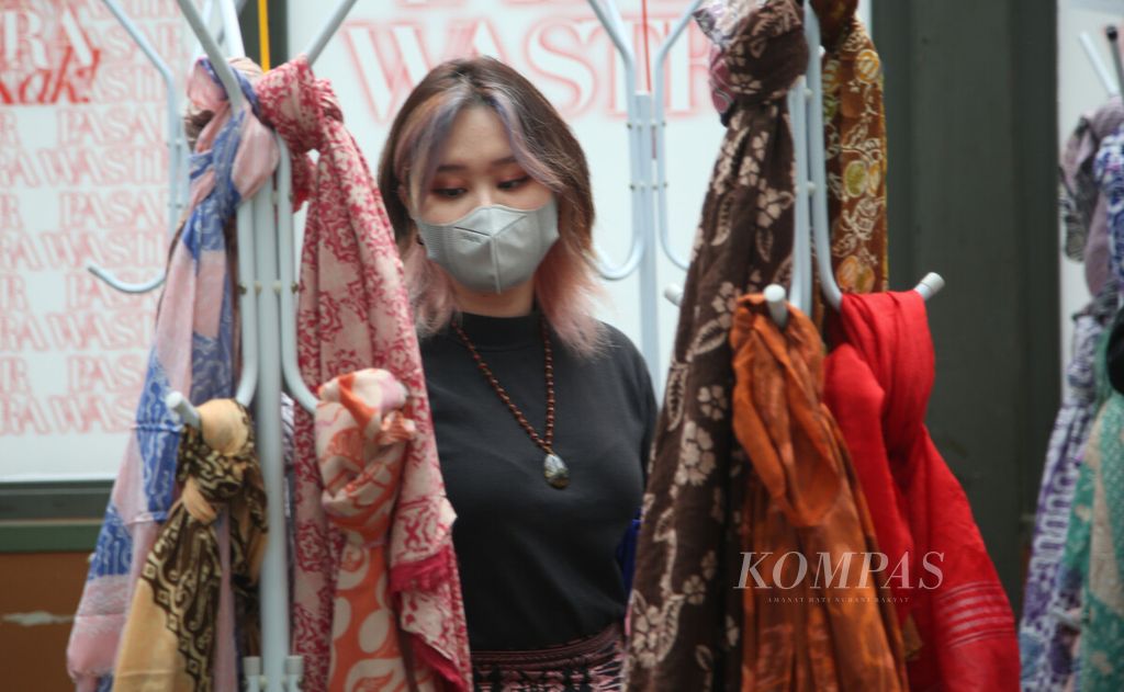 Pengunjung memilih kain yang dijual dalam ajang Pesta Wastra 2022 di kawasan SCBD, Jakarta, Kamis (16/6/2022).