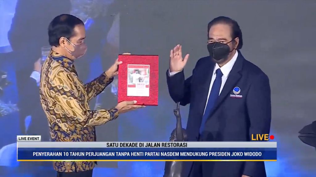 Presiden Joko Widodo menerima simbol dukungan dari Ketua Umum Partai Nasdem Surya Paloh dalam perayaan puncak ulang tahun yang ke-10 Partai Nasdem di Jakarta, Kamis (11/11/2021).