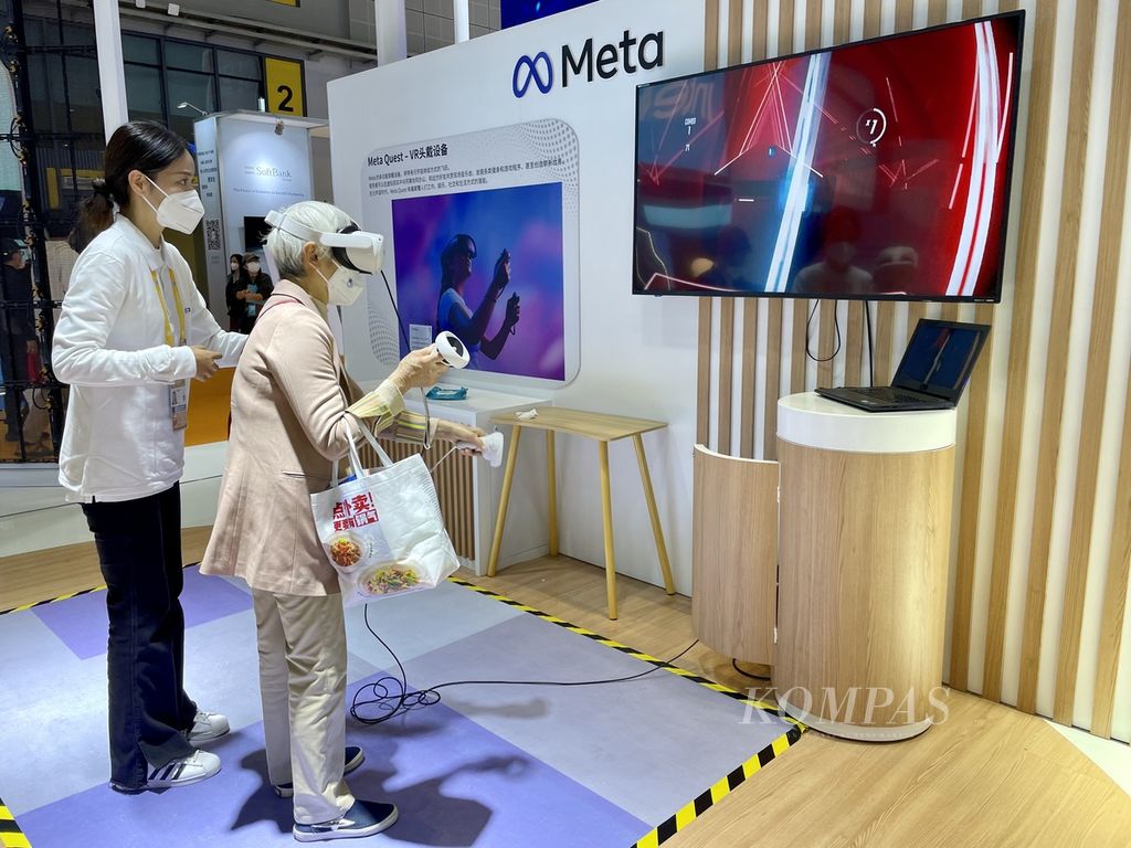 Stan pameran Meta Platform di China International Import Expo, Shanghai, China, dipadati pengunjung yang ingin mencoba bermain dengan <i>virtual reality </i>(VR), Minggu (6/11/2022). Seorang nenek antusias ingin mencoba VR ini. 