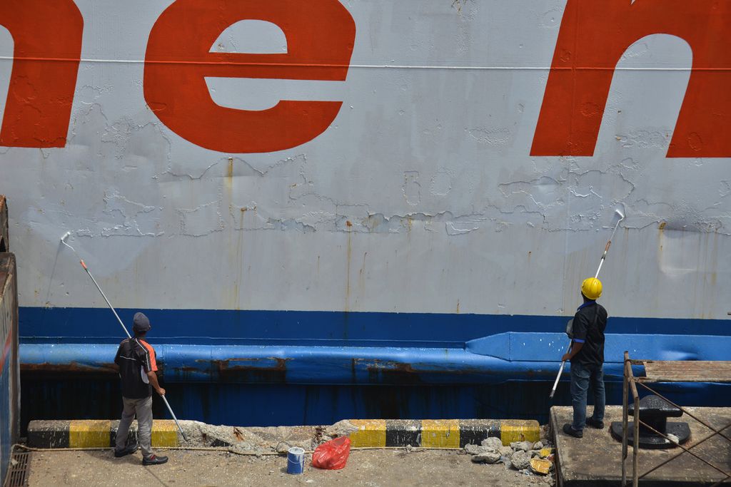  Dua pekerja mengecat feri yang berlabuh di dermaga eksekutif Pelabuhan Merak, Kota Cilegon, Banten, Jumat (7/4/2023).