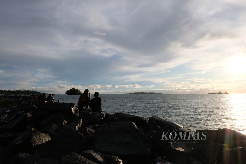 Masyarakat duduk-duduk di pinggir Pantai Dofior di Kota Sorong, Papua Barat Daya, Kamis (31/8/2023) petang. 