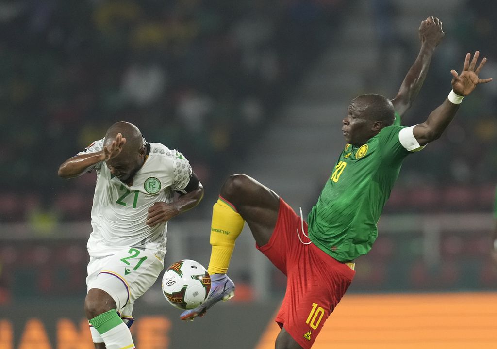 Pemain Komoros, El Fardou Ben Nabouhane (kiri), melindungi tubuhnya dari potensi benturan dengan pemain Kamerun, Vincent Aboubakar, pada laga babak 16 besar Piala Afrika 2021 di Stadion Olembe, Kamerun, Senin (24/1/2022) malam waktu setempat. Kamerun menang, 2-1.