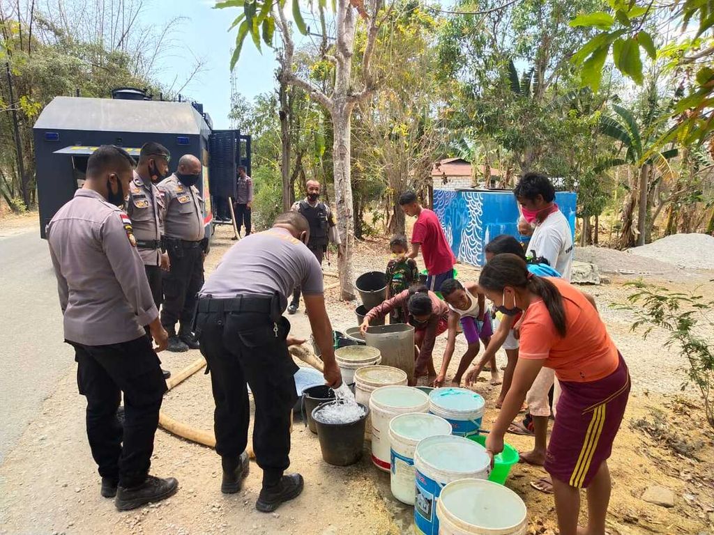 Anggota Polda NTT membagikan air bersih kepada warga di Kelurahan Manulai, Kota Kupang, pada puncak kemarau, November 2020. 