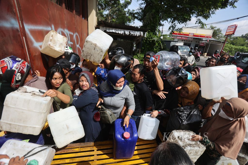 Residents queue to buy cooking oil at a distributor in Muntilan District, Magelang, Central Java, Monday (21/3/2022). The purchase of cooking oil for Rp 15,500 per kilogram in that place is limited to 16 kilograms per person..