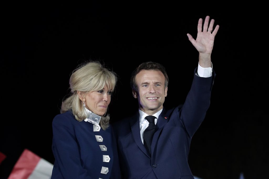 Presiden Perancis Emmanuel Macron dan Ibu Negara Brigitte Macron menyapa para pendukungnya setelah memenangi pemilihan umum presiden untuk masa jabatan kedua di Paris, 24 April 2022. Macron kini sedang menjamu Raja Charles III dari Inggris.