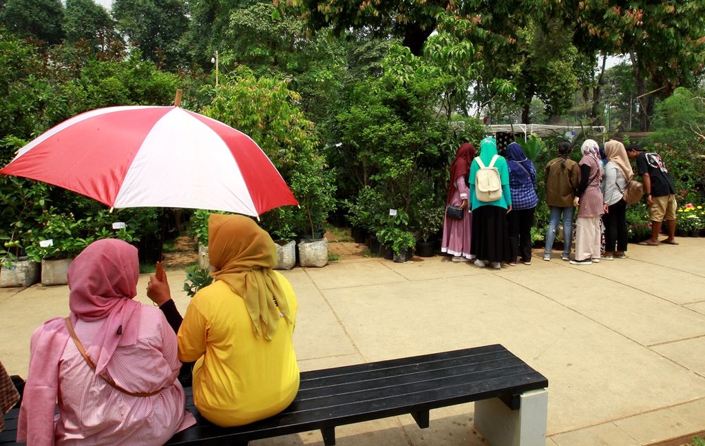 Pengunjung pameran beristirahat sejenak dengan menggunakan payung agar terhindar dari sinar matahari. Pameran flora dan fauna yang digelar di kawasan Lapangan Banteng, Jakarta, Minggu (29/9/2019) itu dikunjungi banyak  warga DKI Jakarta dan sekitarnya. Pameran itu menawarkan berbagai tumbuhan dan tanaman hias.