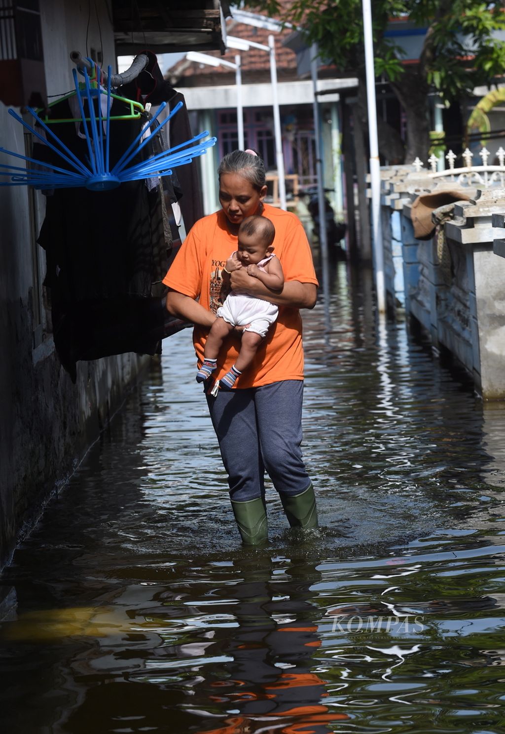 Warga Aisyah menggendong anaknya, Adiba, saat banjir melanda Desa Kedung Banteng, Kecamatan Tanggulangin, Kabupaten Sidoarjo, Jawa Timur, Kamis (6/2/2020). 