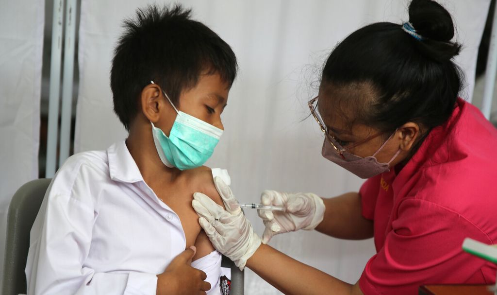 Siswa sekolah menerima suntikan vaksin Sinovac di SDN 02 Pondok Bambu, Jakarta Timur, Selasa (14/12/2021). Sebanyak 141 siswa kelas III menerima suntikan vaksin Sinovac di sekolah tersebut. Kementerian Kesehatan memulai vaksinasi Covid-19 untuk anak usia 6-11 tahun dengan jumlah sasaran vaksinasi mencapai 26,5 juta orang di Indonesia. Pada tahap awal, vaksinasi Covid-19 bagi anak usia 6-11 tahun digelar di sekolah dasar atau sederajat. 