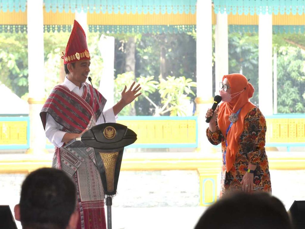 Presiden Joko Widodo berinteraksi dengan anggota tim percepatan penurunan <i>stunting</i> Kota Medan, Deni Andayuni, dalam peringatan Hari Keluarga Nasional 2022, di Medan, Sumatera Utara, Kamis (7/7/2022).