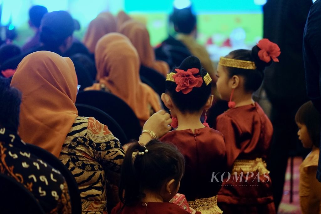Seorang ibu merapikan anting milik anaknya di acara wisuda TK Kuncup Pertiwi, di Kendari, Sulawesi Tenggara, Senin (19/6/2023).