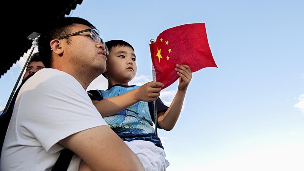 Seorang pria menggendong anak laki-lakinya di sebuah taman di Beijing, China, 6 September 2018. 