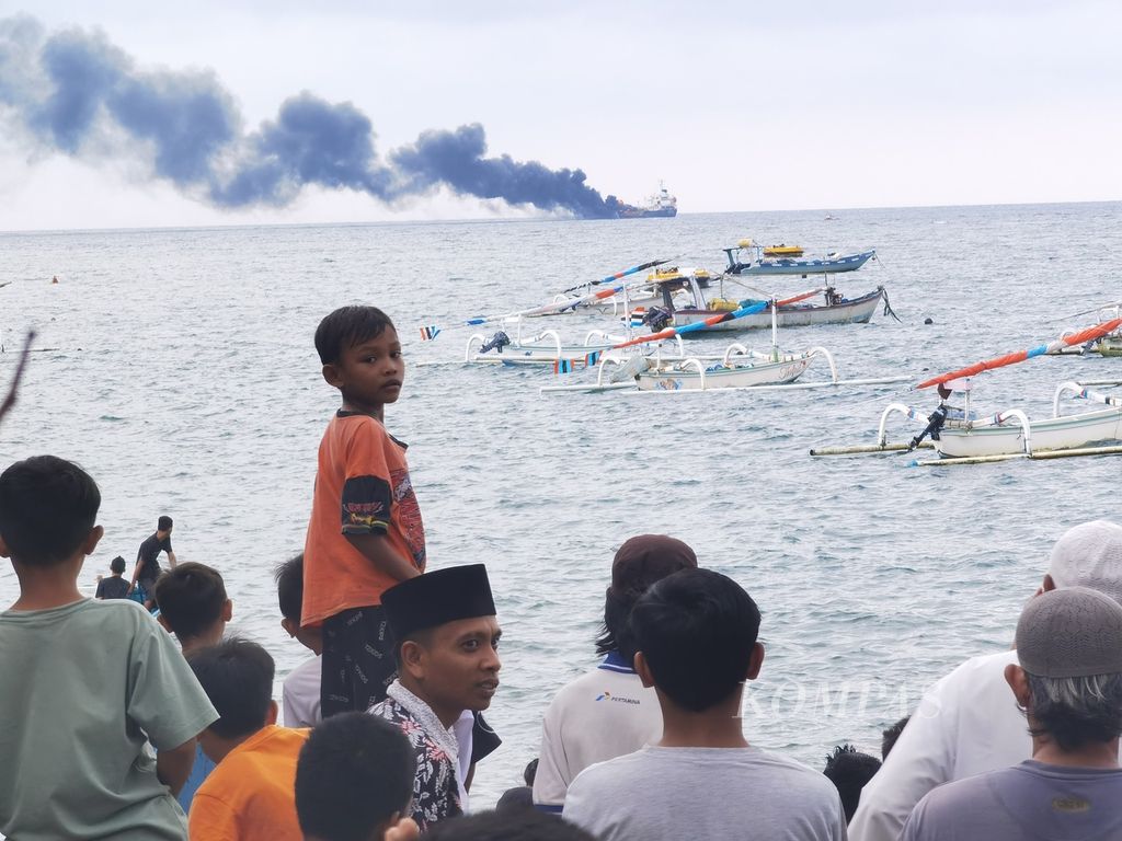 Warga memadati pantai untuk melihat kapal MT Kristin yang terbakar di perairan barat Pulau Lombok, tepatnya di kawasan Pantai Ampenan, Kota Mataram, Nusa Tenggara Barat, Minggu (26/3/2023) sore. 