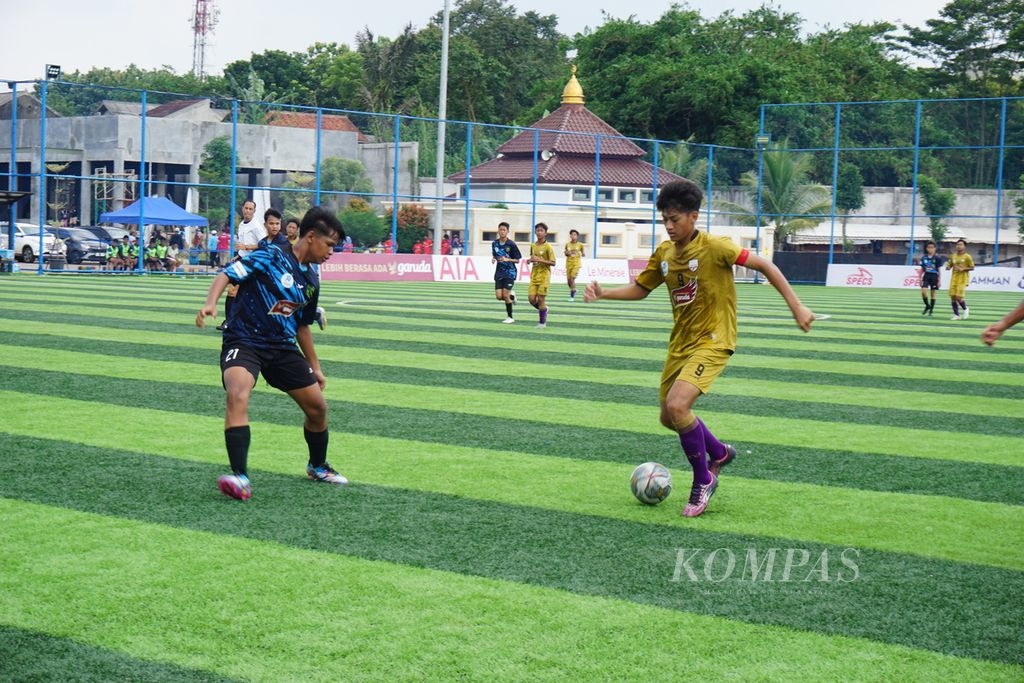 Pemain Asiana Soccer School, M Mierza Firjatullah, berusaha menembus pertahanan SSB Maesa dalam laga pekan ke-13 Liga Kompas Kacang Garuda U-14 di Lapangan Dewantara, Tangerang Selatan, Banten, Minggu (18/2/2024).