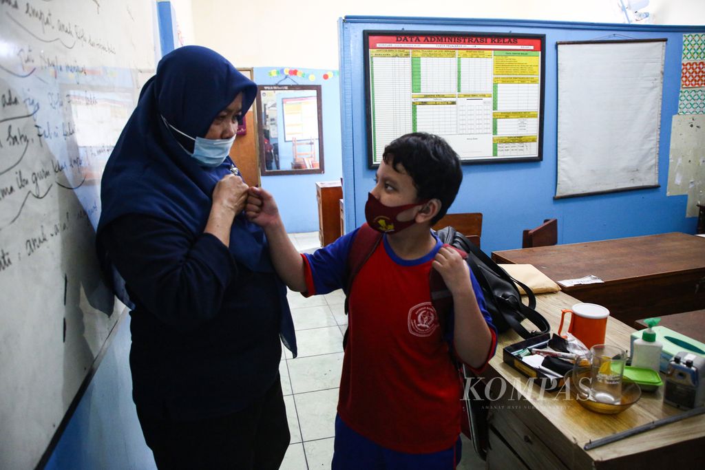 Siswa tunarungu berpamitan kepada gurunya dalam uji coba belajar tatap muka hari pertama di SLB Sumber Budi, Jakarta Selatan, Selasa (31/8/2021).
