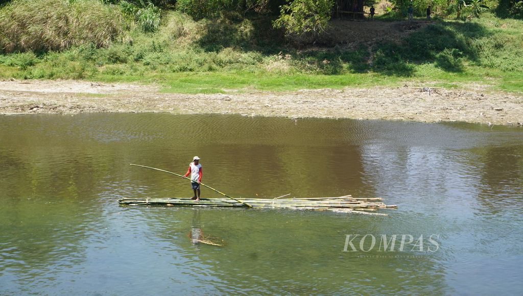 Seorang warga melintas dengan perahu bambu di aliran Sungai Bengawan Solo, Kabupaten Sukoharjo, Jawa Tengah, Kamis (9/9/2021). Diduga terjadi pencemaran akibat limbah minuman beralkohol, dengan jenis ciu, yang dibuang ke sungai tersebut. Akibatnya, PDAM Toya Wening Kota Surakarta sempat menghentikan operasional salah satu instalasi pengolahan airnya akibat kepekatan air yang meningkat.