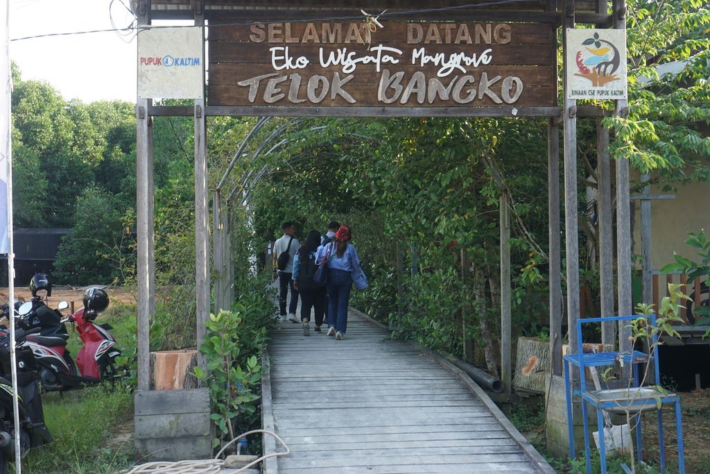 Warga menyusuri jembatan kayu ulin di Wisata Mangrove Teluk Bangko, Kelurahan Loktuan, Kecamatan Bontang Utara, Kota Bontang, Kalimantan Timur, Minggu (23/7/2023).