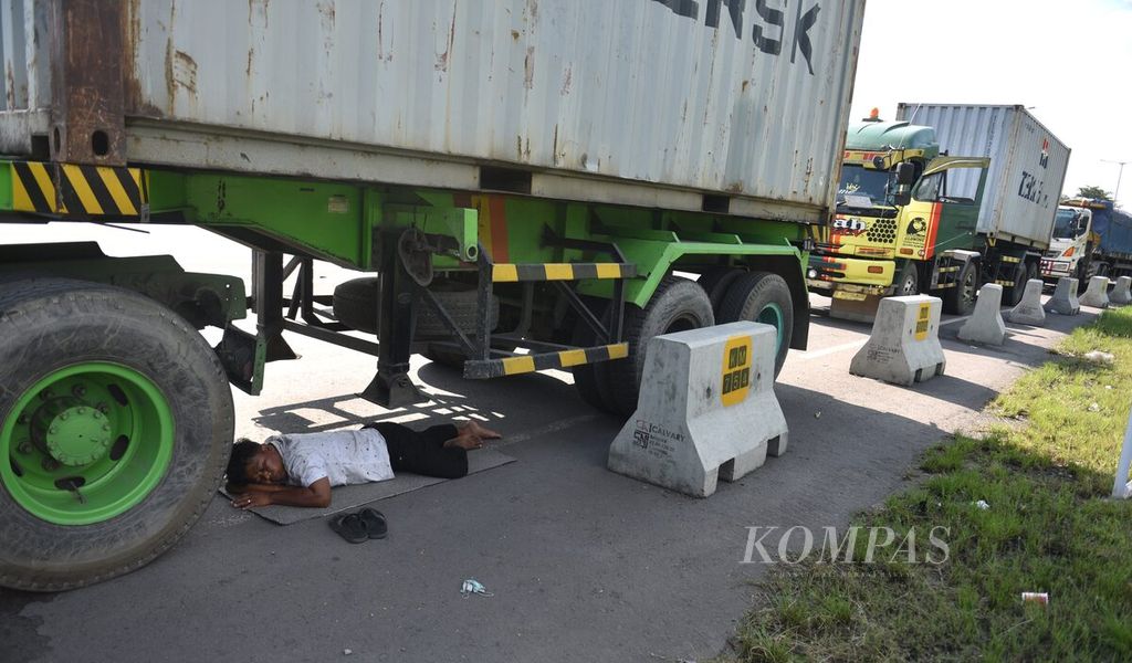 Yabaniadama, truck driver fell asleep under his truck while waiting in line to get diesel at the Rest Area KM 754 gas station on the Surabaya-Gempol toll road, Sidoarjo Regency, East Java, Tuesday (5/4/2022). Many truck drivers admit to having diesel problems in the last five days. 