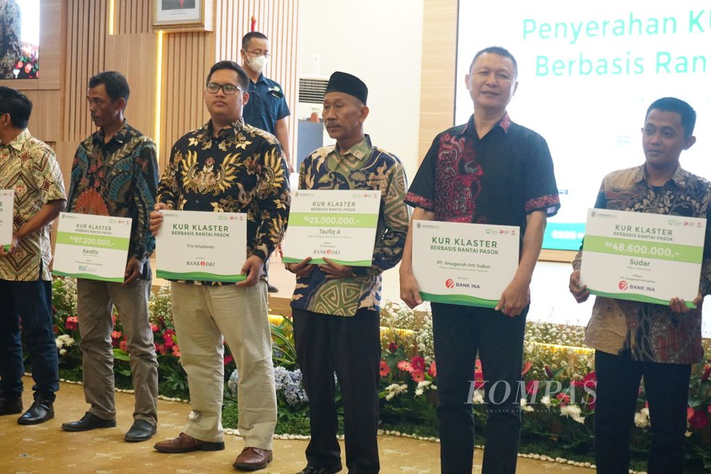 Para pengusaha mikro, kecil, dan menengah yang telah dinaungi perusahaan sebagai pembeli produk secara simbolis menerima kredit usaha rakyat (KUR) berbasis kluster, Rabu (12/4/2023), di Jakarta. 