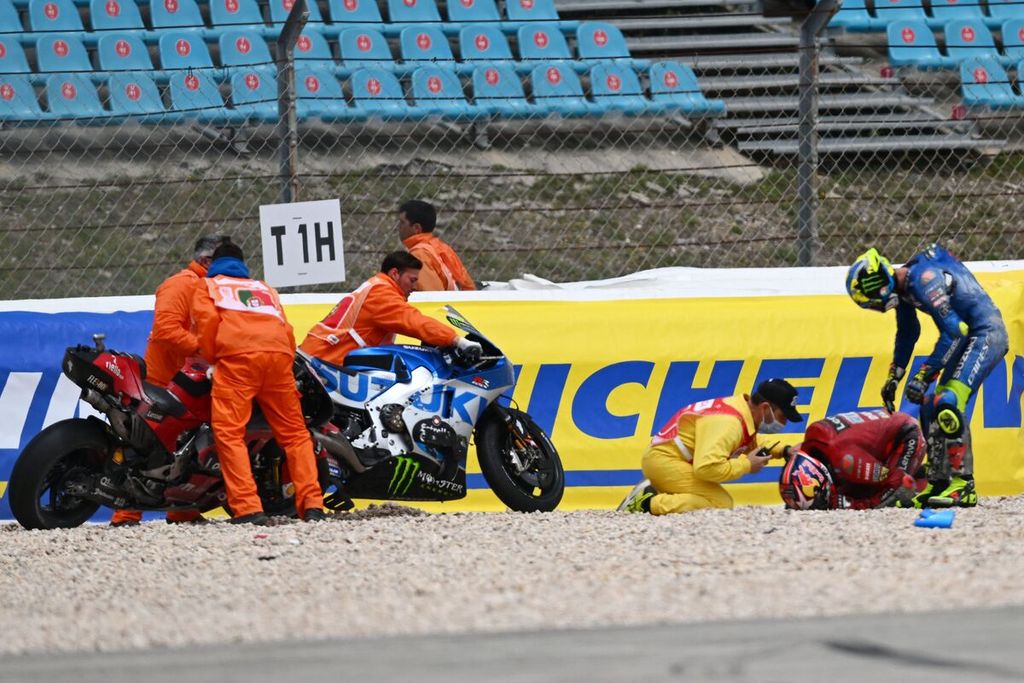 Pebalap Suzuki Joan Mir (kanan) memeriksa pebalap Ducati Jack Miller setelah keduanya terjatuh pada MotoGP seri Portugal di Sirkuit Internasional Algarve, Portimao, Minggu (24/4/2022). 