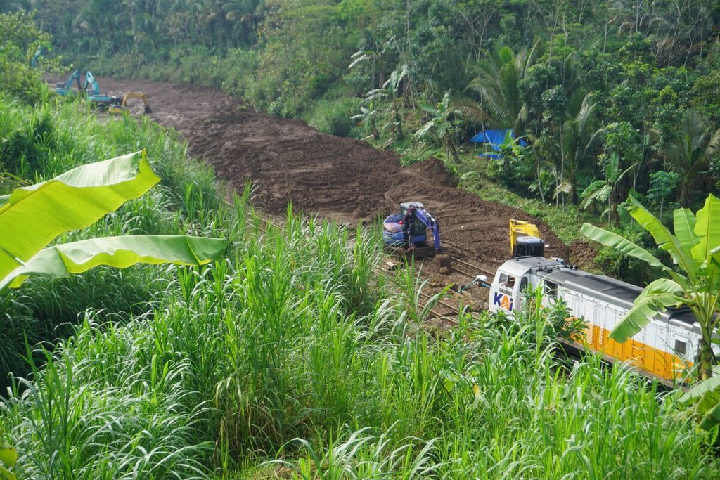 Sebuah kereta dari arah barat menuju Purwokerto melintasi rel jalur hilir yang sudah dibersihkan dari material longsoran di Desa Gununglurah, Kecamatan Cilongok, Kabupaten Banyumas, Jawa Tengah, Selasa (5/12/2023).