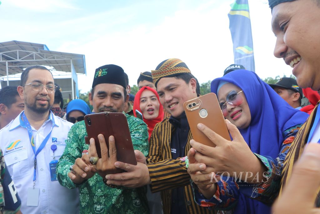 Menteri Badan Usaha Milik Negara Erick Thohir (kedua dari kanan) berswafoto bersama warga saat meninjau pembangunan pabrik minyak makan merah Pagar Merbau di Kabupaten Deli Serdang, Sumatera Utara, Jumat (6/1/2023). 