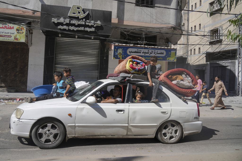 Anak-anak memenuhi mobil yang mengangkut mereka dari Gaza Utara ke Gaza Selatan, Jumat (13/10/2023). Israel meminta Gaza Utara dikosongkan karena akan jadi sasaran serangan besar-besaran.
