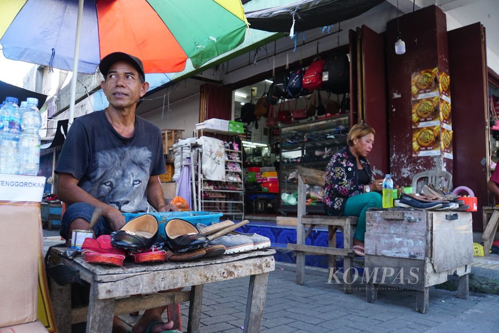 Arifin Lahabu (54, kiri), seorang tukang sol sepatu, melapak di daerah Pasar 45, Manado, Sulawesi Utara, Senin (15/5/2023).