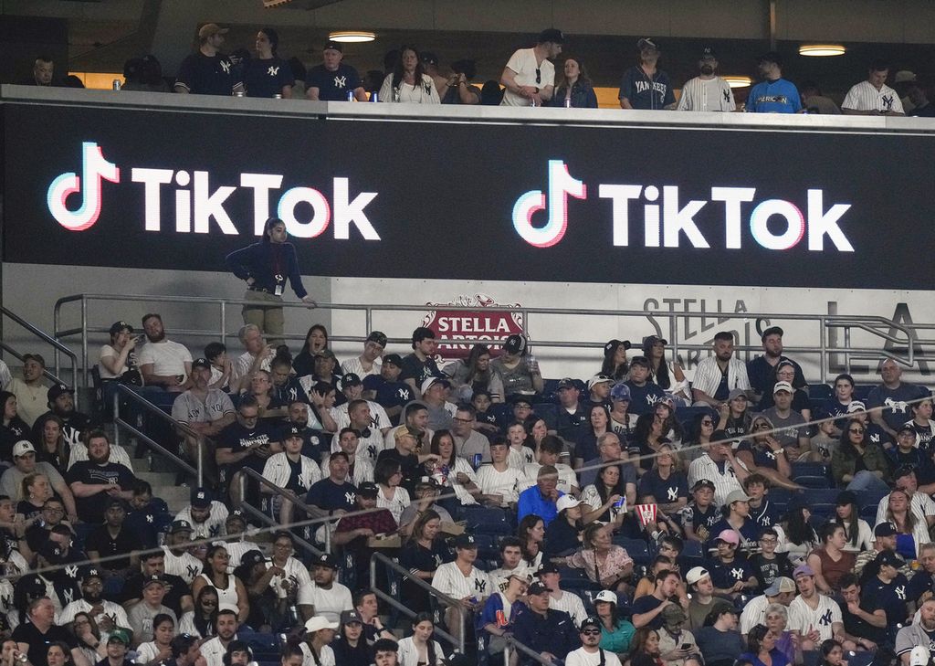 Pendukung Tiktok duduk di bawah iklan Tiktok pada pertandingan bisbol di Yankee Stadium, 14 April 2023, di New York. AS. RUU yang dapat menyebabkan Tiktok dilarang di AS mendapatkan perhatian di DPR. 